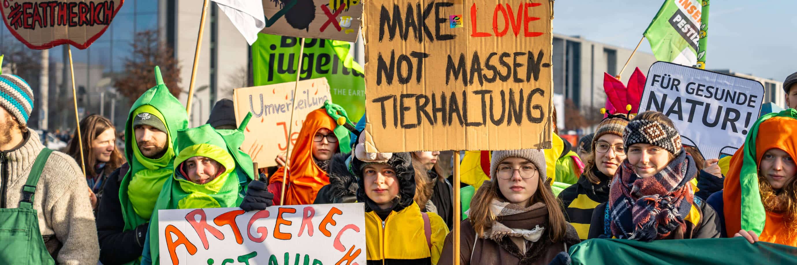Protestierende in Kostümen mit Schildern für bessere Umwelt